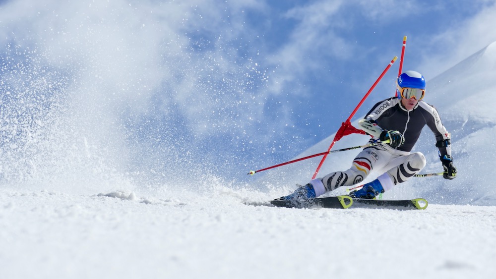 Skier in a racing position on a groomed slope