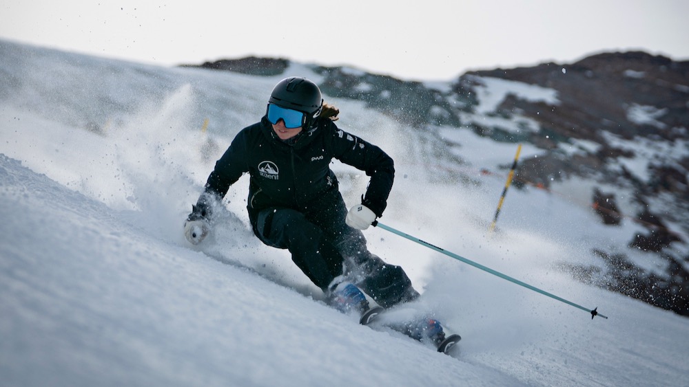 Skier making carved turns on a groomed piste